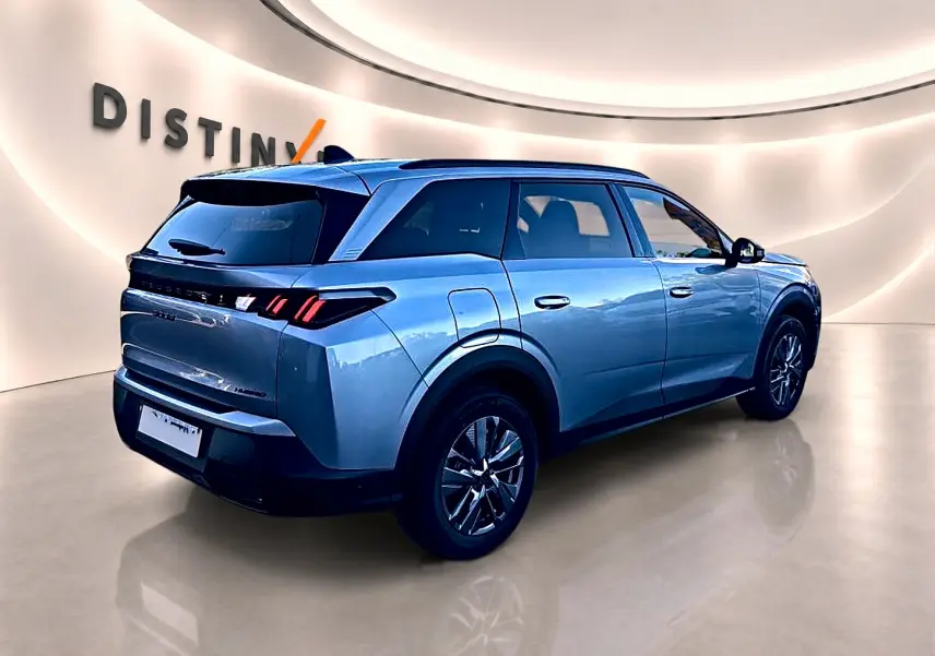 Vue 3/4 arrière droite du Peugeot 5008 gris Artense avec feux arrière LED et jantes alu en showroom.