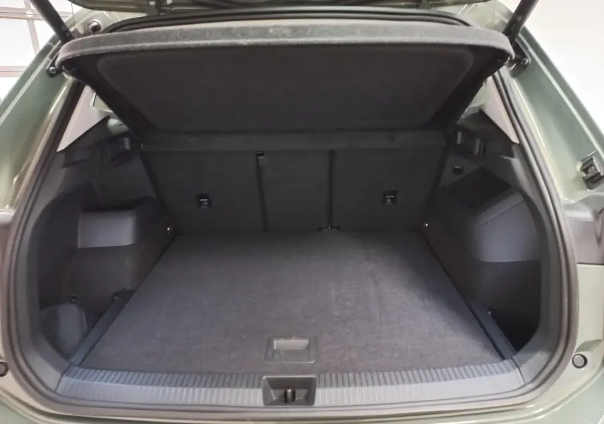 Coffre ouvert du Volkswagen Tiguan 2025 Vert Cipressino, vue arrière montrant l'espace de chargement vide.