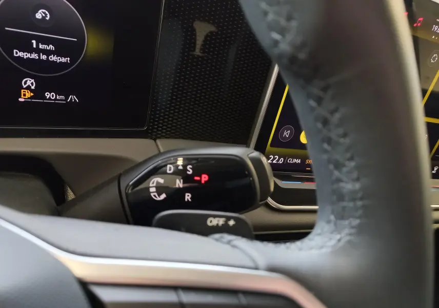 Gros plan sur le levier de vitesses automatique DSG7 du Volkswagen Tiguan 2025, avec tableau de bord numérique en arrière-plan.