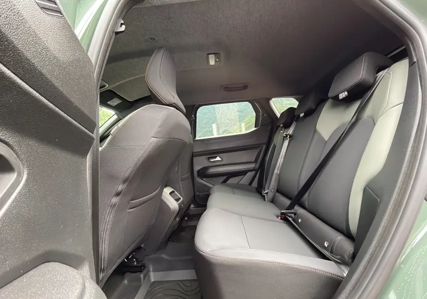 Vue côté gauche sur la banquette arrière grise et noire du Dacia Duster 2025 kaki lichen, intérieur spacieux et moderne.
