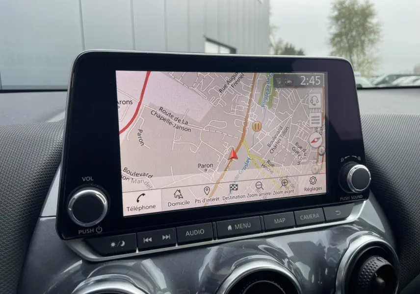 Écran tactile 8 pouces du Nissan Juke 2024 affichant la navigation, vu de face dans l'habitacle gris.