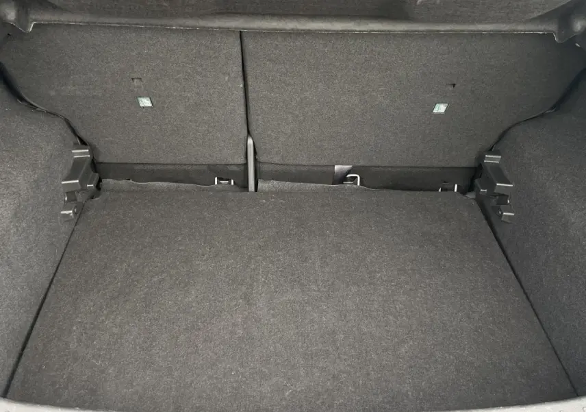 Coffre vide en vue plongeante du Nissan Juke 2024 gris Silver, montrant l'espace de chargement et le revêtement intérieur.