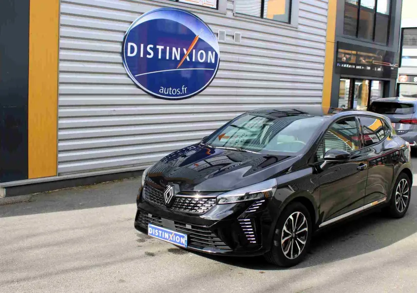 Renault Clio hybride noire étoile métal vue 3/4 avant droit, avec calandre distinctive et jantes bicolores.