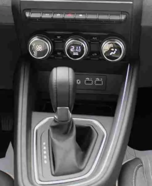 Vue centrée de la console centrale de la Renault Clio 2025 avec écran tactile, commandes climatisation et levier de boîte auto.