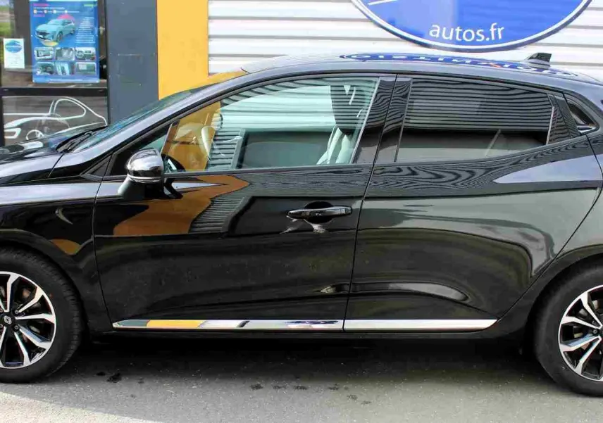 Profil côté gauche de la Renault Clio noire étoile métal 2025 avec jantes alliage bicolores et poignées de porte chromées.