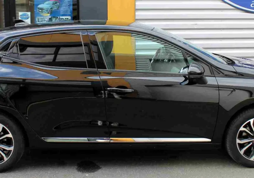 Profil côté gauche de la Renault Clio 2025 noire étoile métal avec jantes alliage bicolores et vitres teintées.