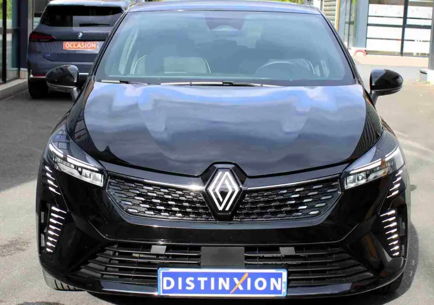 Vue avant d'une Renault Clio noire étoile métal 2025 avec calandre moderne et feux LED verticaux allumés.