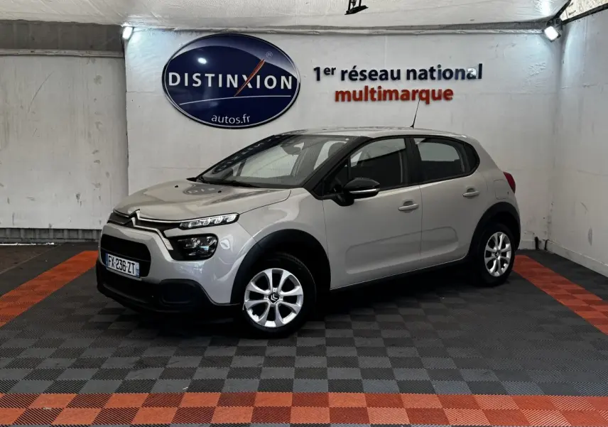Citroën C3 beige vue 3/4 avant droit en intérieur, avec phares LED et jantes alliage visibles.
