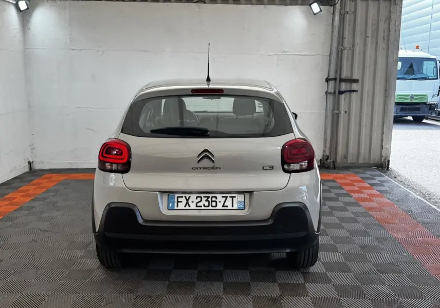Vue arrière d'une Citroën C3 beige 2021 stationnée dans un garage avec plaques d'immatriculation françaises visibles.