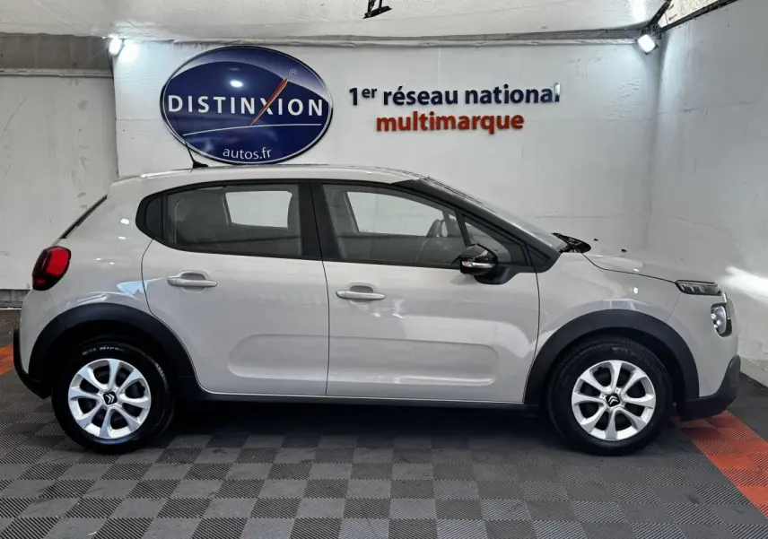 Vue latérale droite d'une Citroën C3 beige 2021 avec protections noires et jantes alliage en showroom.