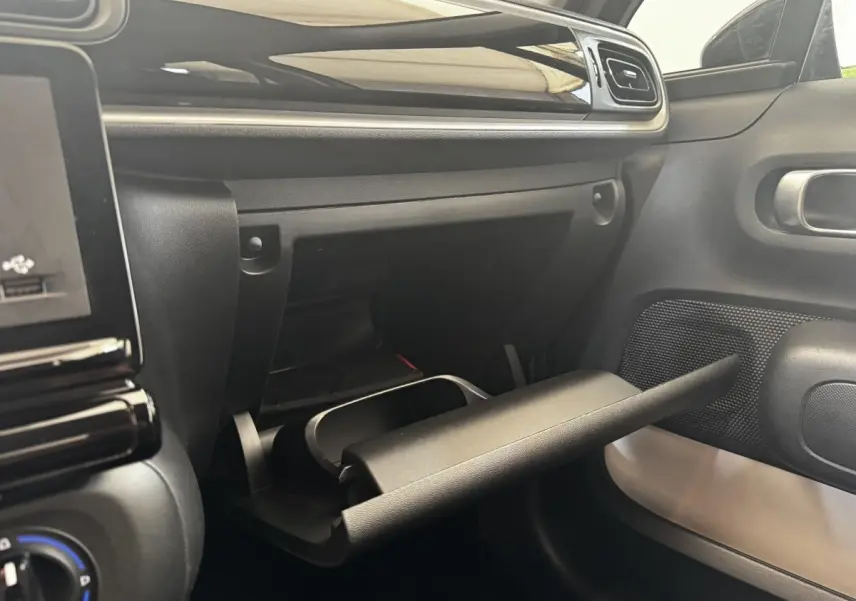 Intérieur de la Citroën C3 PureTech 83 S&S BVM Feel 2021, vue sur la boîte à gants ouverte côté passager.