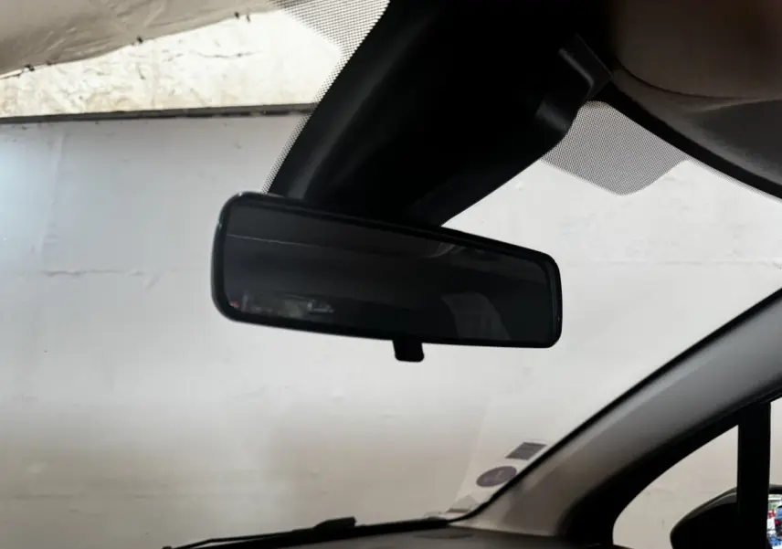 Rétroviseur intérieur noir de la Citroën C3 beige, vue depuis l’habitacle côté conducteur.