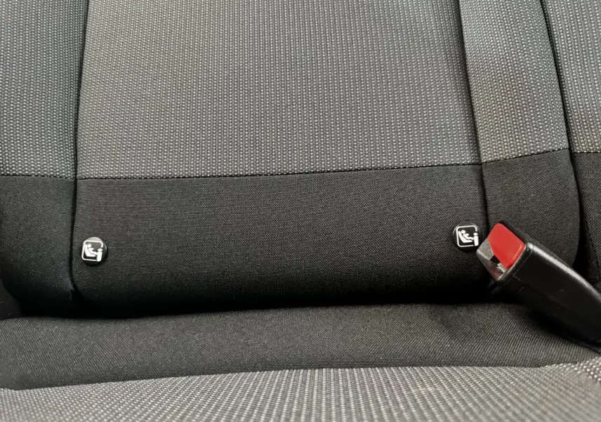 Détail de la banquette arrière noire et grise du Citroën C3 PureTech 83 S&S BVM Feel avec logos Isofix et boucle de ceinture rouge.