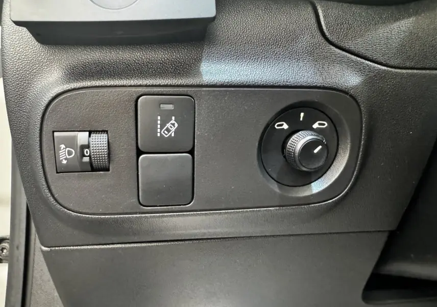 Vue rapprochée des commandes de réglage des phares et des rétroviseurs sur une Citroën C3 beige 2021.
