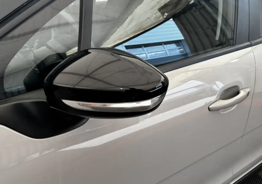 Gros plan sur le rétroviseur noir avec clignotant intégré côté conducteur d'une Citroën C3 beige 2021.
