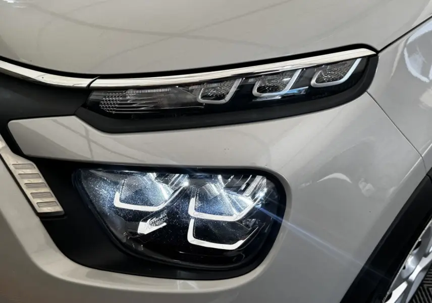 Gros plan sur le phare avant droit beige de la Citroën C3 PureTech 83 S&S BVM Feel 2021 avec feux LED distinctifs.