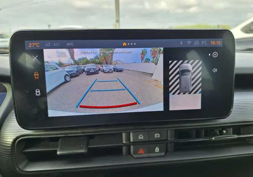 Écran intérieur montrant la caméra de recul avec vue arrière et angles de stationnement du Jeep Avenger blanc.