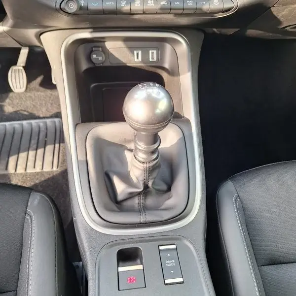 Vue rapprochée de la console centrale du Jeep Avenger 2025 avec levier de vitesse manuel et commandes électroniques.