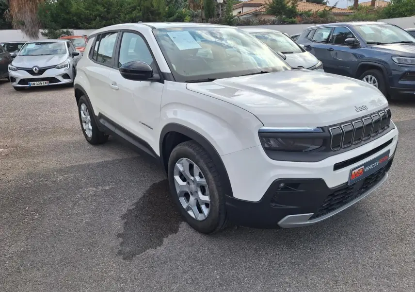 Jeep Avenger blanc vu en 3/4 avant droit, avec calandre noire distinctive et jantes alliage 17 pouces.
