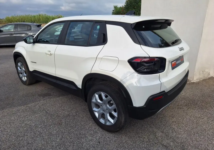 Vue 3/4 arrière droite d'un Jeep Avenger blanc 2025 avec jantes alliage 17 pouces et feux arrière noirs.