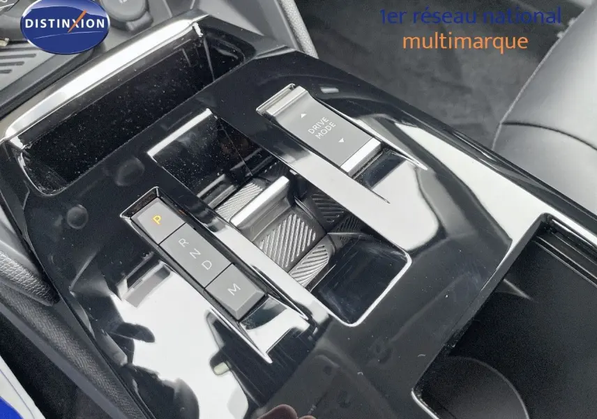 Gros plan sur la console centrale noire brillante de la Citroën C4 blanche 2024, mettant en valeur le sélecteur de boîte auto et le bouton Drive Mode.