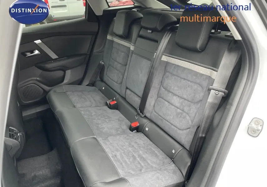 Banquette arrière en cuir noir et tissu gris de la Citroën C4 blanche, vue côté gauche avec ceinture de sécurité visible.
