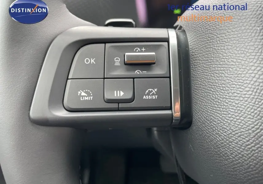 Gros plan sur les commandes au volant du Citroën C4 blanc métal 2024, mettant en valeur les boutons d'assistance et de limitation.