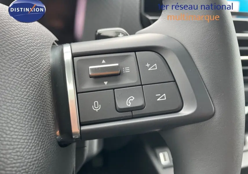 Gros plan sur les commandes au volant de la Citroën C4 2024, avec boutons de volume et téléphone intégrés.