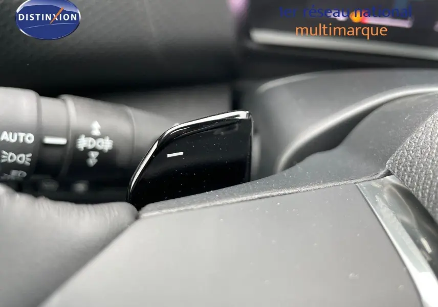 Gros plan sur la palette de changement de vitesse noire côté gauche du volant d'une Citroën C4 blanche métal 2024.