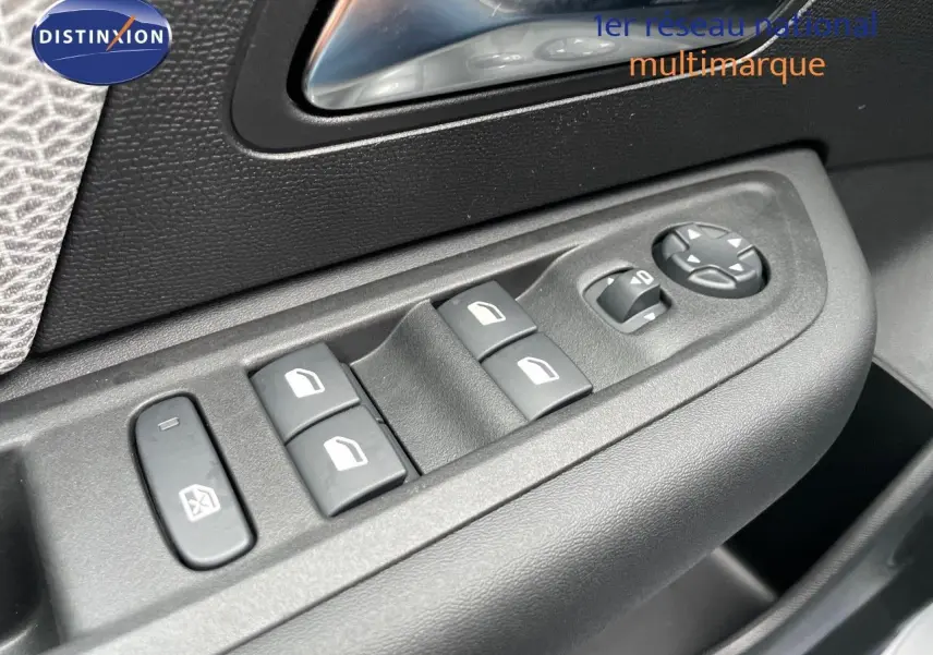 Gros plan sur les commandes de lève-vitres et rétroviseurs côté conducteur d'une Citroën C4 blanche métal 2024.