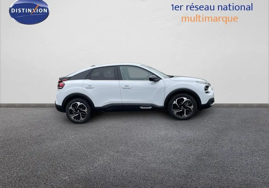 Profil côté gauche d'une Citroën C4 blanche métal 2024 avec jantes noires et toit noir contrasté.