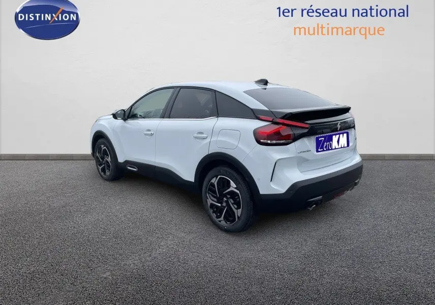 Citroën C4 blanc métal vue 3/4 arrière droit, avec toit noir et jantes alliage bicolores distinctives.