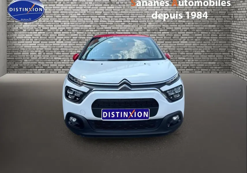 Vue frontale d'une Citroën C3 2023 blanche avec toit rouge, calandre noire et projecteurs antibrouillard visibles.