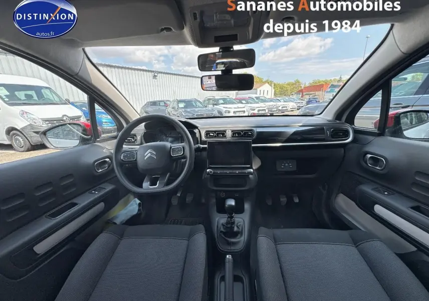 Vue intérieure avant de la Citroën C3 2023 avec tableau de bord noir et volant multifonction.