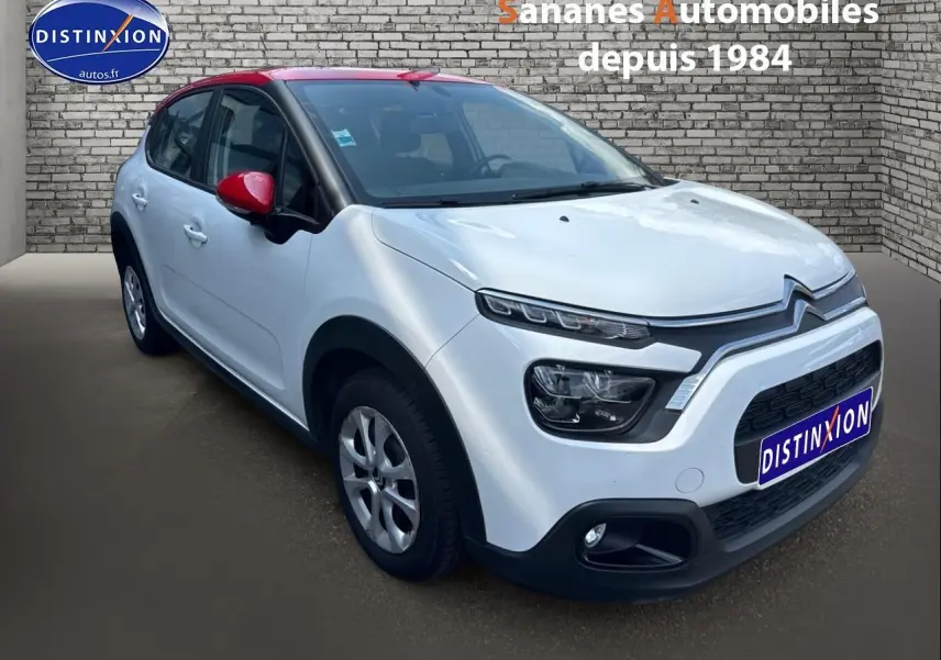 Citroën C3 blanc Banquise avec toit et rétroviseurs rouges, vue 3/4 avant droit sur fond urbain.