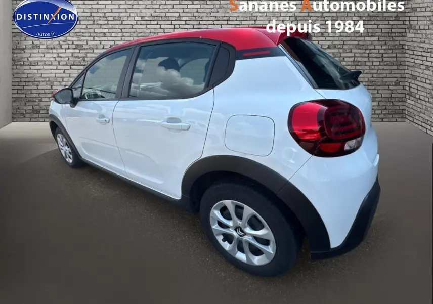 Citroën C3 2023 blanc banquise avec toit rouge, vue 3/4 arrière côté gauche, élargisseurs d'ailes noirs mats visibles.