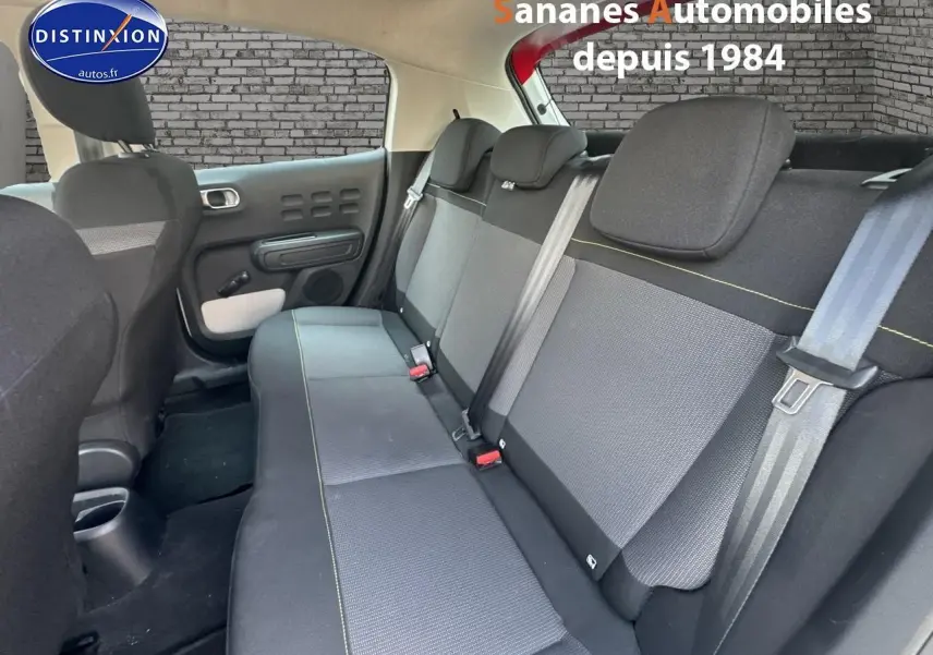 Vue intérieure sur la banquette arrière grise avec surpiqûres jaunes de la Citroën C3 2023 toit rouge et caisse blanche.