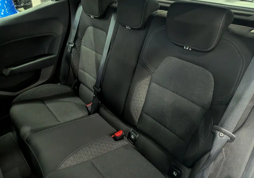 Vue intérieure des sièges arrière en tissu noir et gris de la Renault Clio V Business, avec ceintures de sécurité visibles.