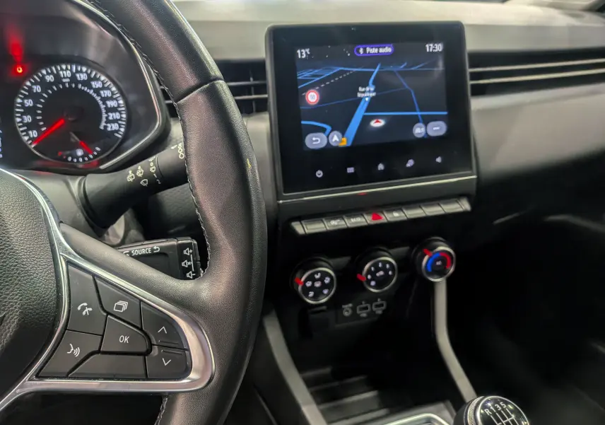 Vue intérieure du tableau de bord de la Renault Clio V Business 2020, avec écran tactile et volant multifonction noir.