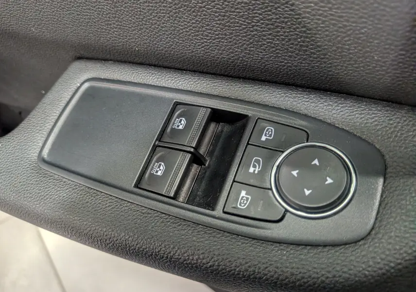 Gros plan sur les commandes de lève-vitres et réglage des rétroviseurs côté conducteur d'une Renault Clio V Business 2020.