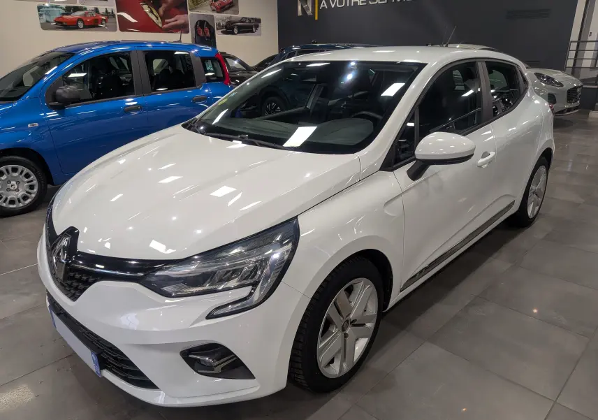 Renault Clio V Blue dCi 115 Business blanc glacier vue 3/4 avant droit en intérieur showroom.