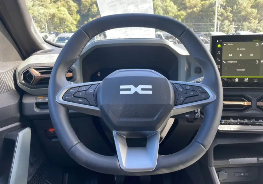 Vue intérieure centrée sur le volant cuir du Dacia Bigster TCE 130 4x4 Extreme Plus avec tableau de bord digital.