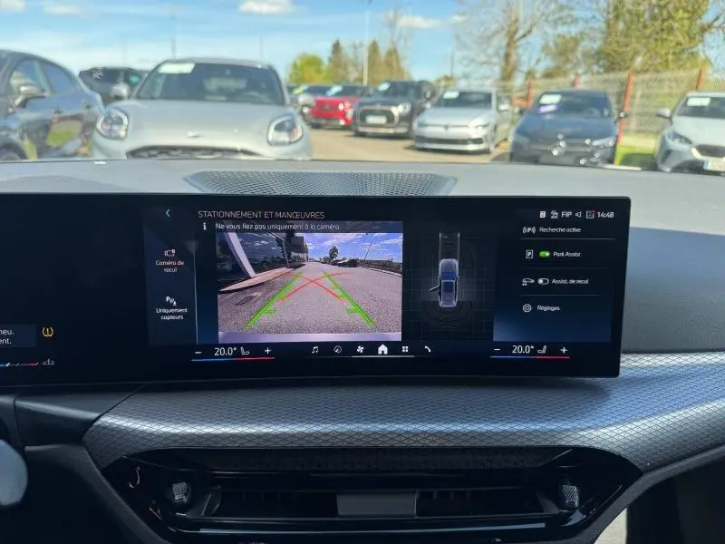 Vue depuis l'intérieur sur l'écran de recul de la BMW Série 3 320dA xDrive M Sport, avec affichage des aides au stationnement.