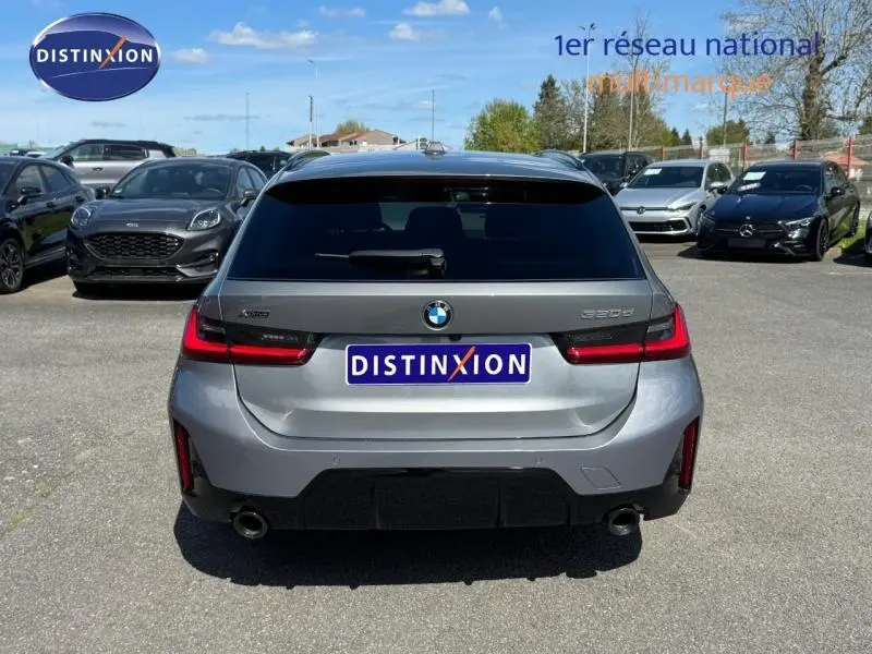 Vue arrière d'une BMW Série 3 320dA xDrive M Sport 2025 en gris métallisé Skyscrapergrau, avec feux LED et double sortie d'échappement.