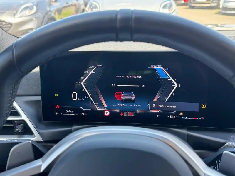 Vue du tableau de bord numérique d'une BMW Série 3 320dA xDrive M Sport 2025, affichant une alerte de porte ouverte.