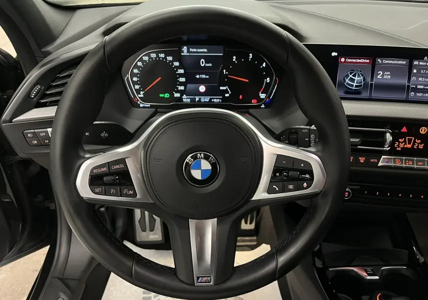 Vue rapprochée du volant M Sport noir avec commandes intégrées et tableau de bord numérique d'une BMW Série 1 F40.