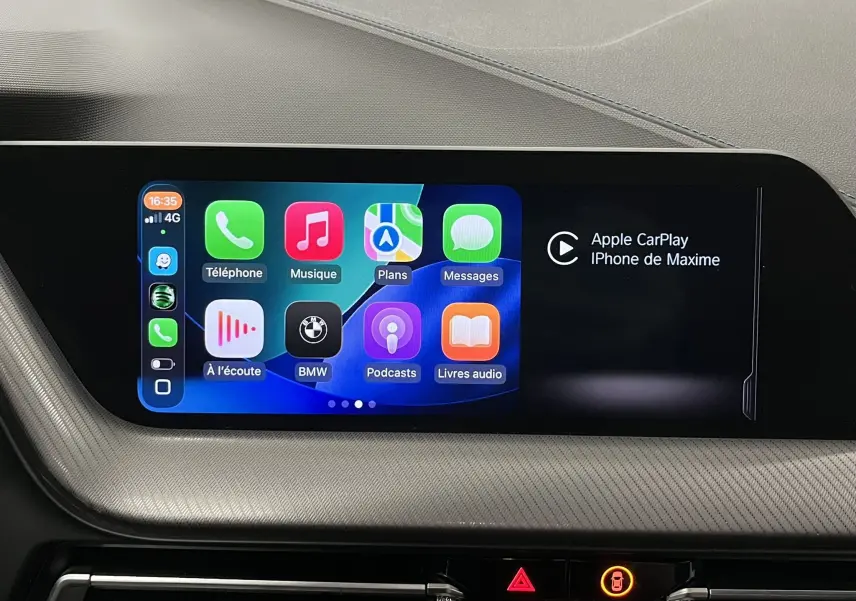 Écran central tactile de la BMW Série 1 F40 noir métallisé affichant Apple CarPlay et applications connectées.