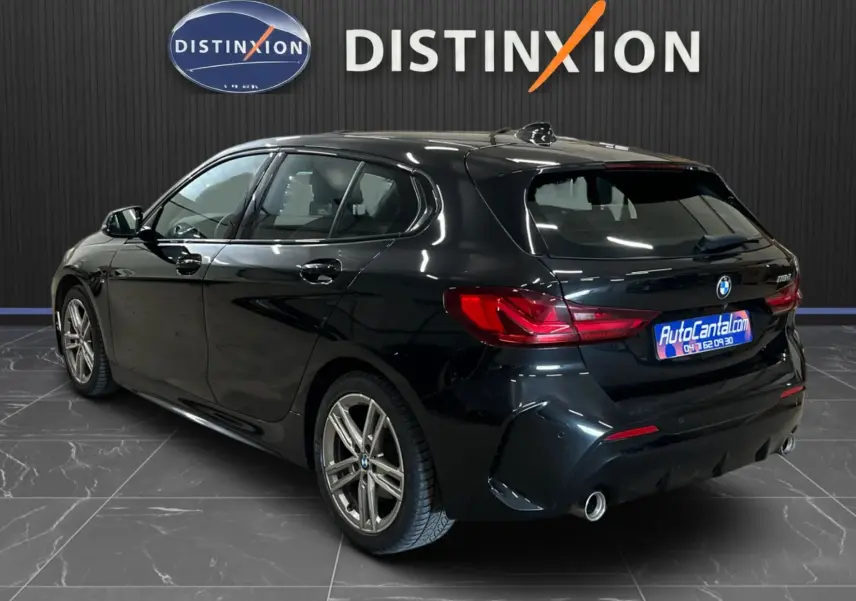 BMW Série 1 F40 118d noir métallisé vue 3/4 arrière droit, avec jantes alliage et feux arrière LED distinctifs.