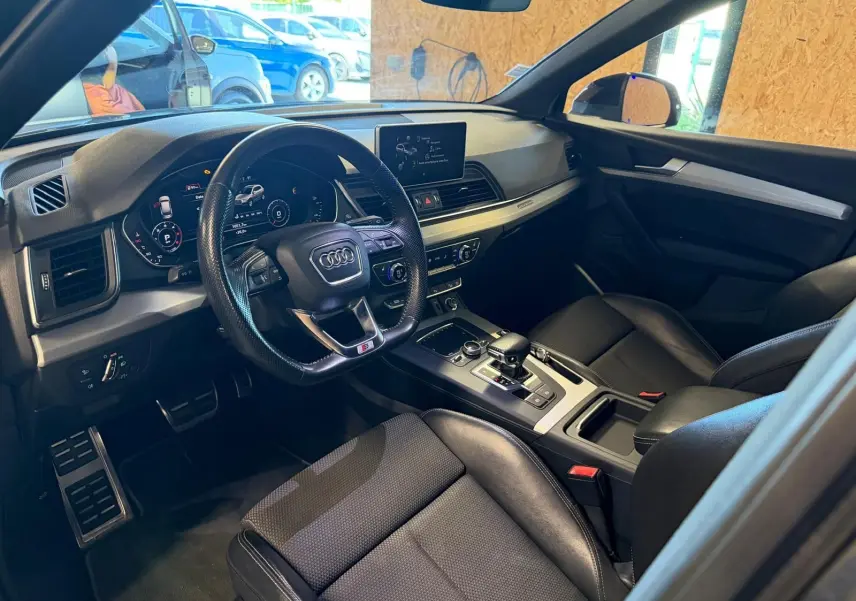 Intérieur noir de l'Audi Q5 Sportback 2019 vu côté conducteur, avec tableau de bord digital et console centrale moderne.