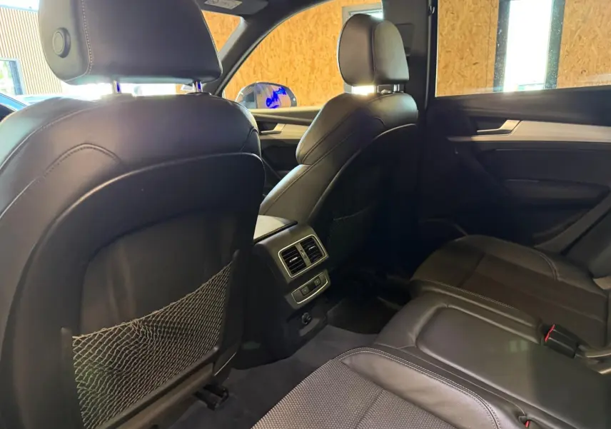 Vue intérieure arrière de l'Audi Q5 Sportback 2019, sièges en cuir noir avec filet de rangement au dos des sièges avant.